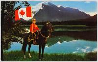 Mountie on horse holding large Canadian flag